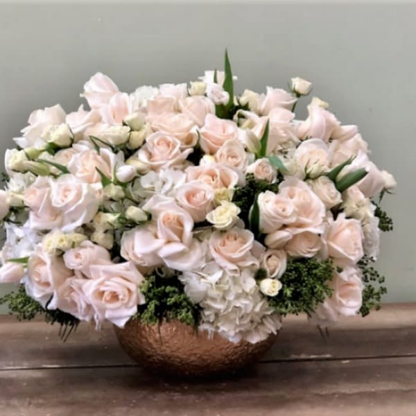 Blush rose arrangement in a copper bowl vase
