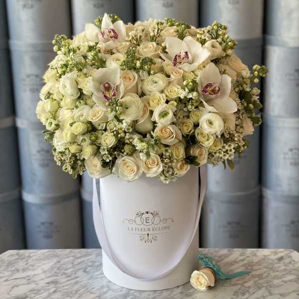 Cream rose and white orchid bouquet in a white hat box