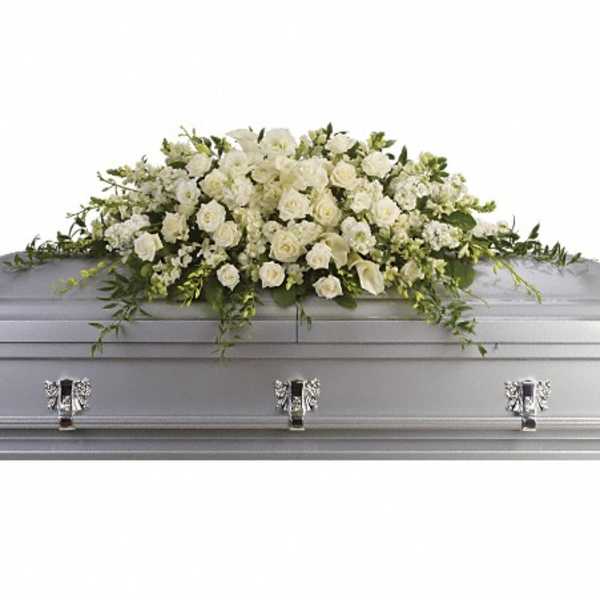 White floral casket spray on a silver casket