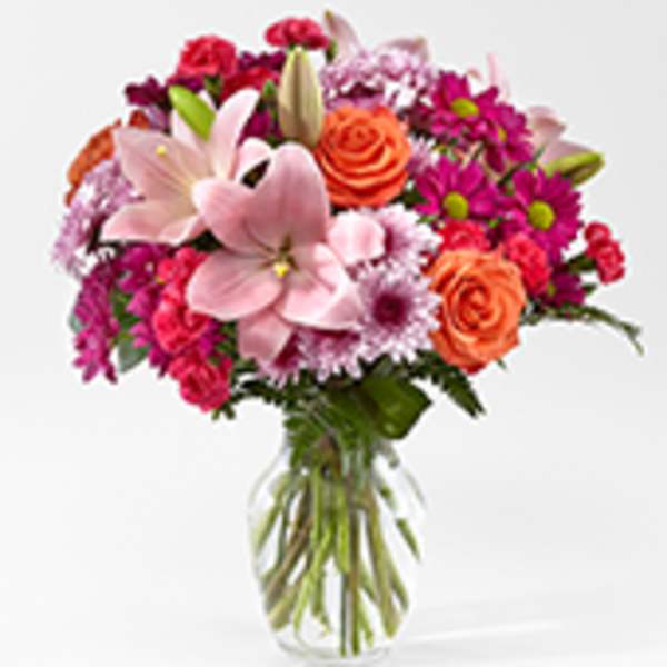 Pink lilies and orange roses in a glass vase