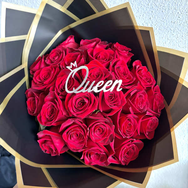 Bouquet of bright pink roses wrapped in black and gold paper