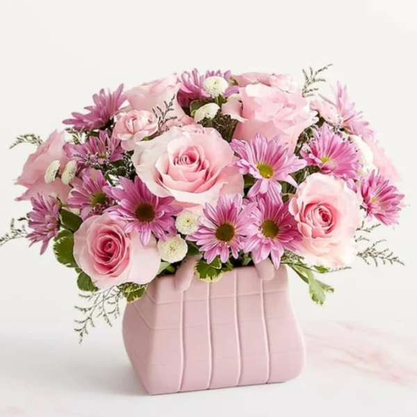 Pink roses and daisies arranged in a pink vase