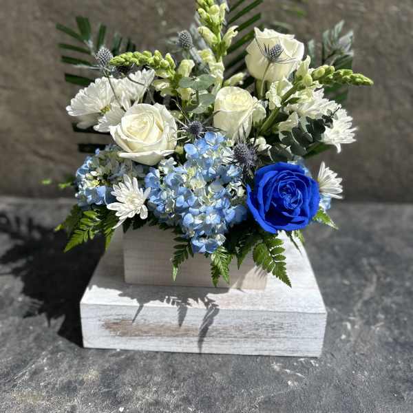 Blue and white floral arrangement in a white box