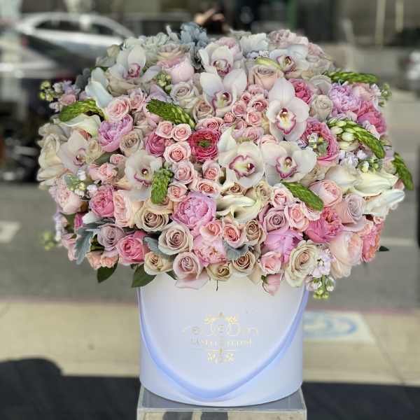 Large pastel bouquet of roses, orchids, and calla lilies in a white hat box