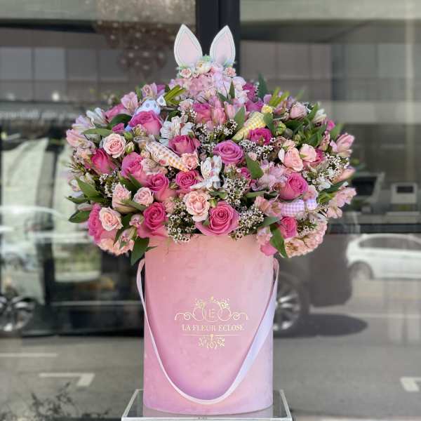 Large pink rose arrangement in a tall pink hatbox with bunny ears