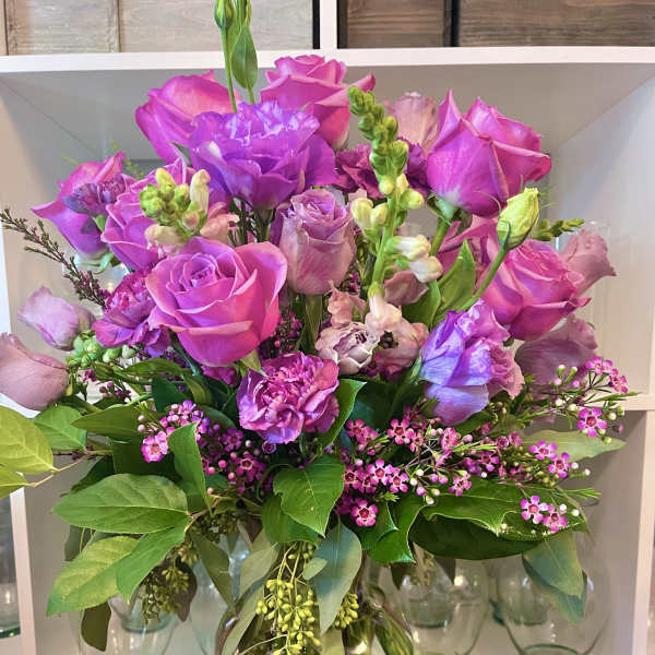 Pink and purple rose bouquet in a glass vase