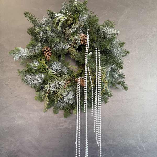 Evergreen wreath with pinecones and hanging white bead strands