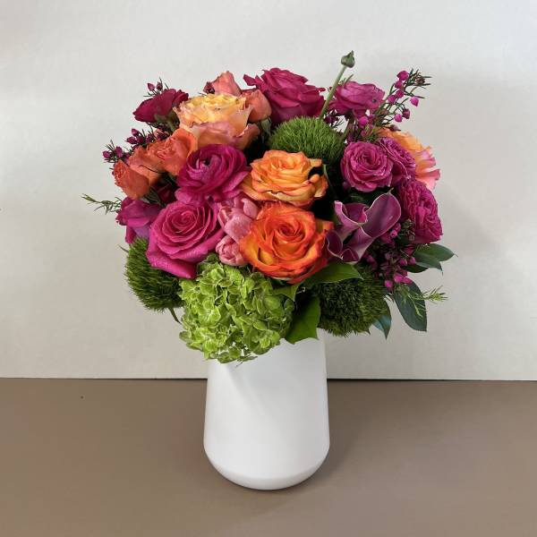 Bright mixed bouquet of roses in a white vase
