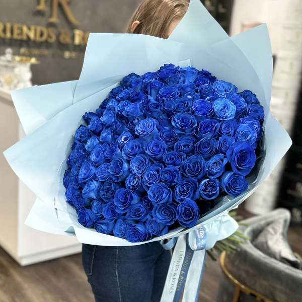 Large bouquet of vivid blue roses wrapped in pale blue paper