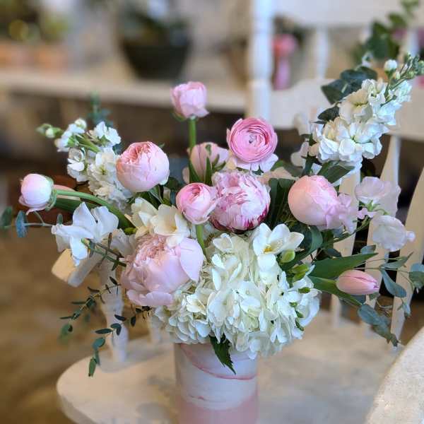 Pink and white floral arrangement in a pink vase