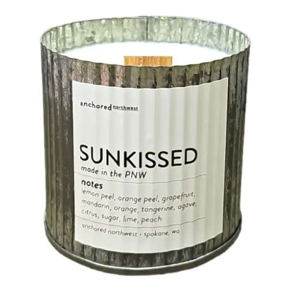 Scented candle in a woodgrain tin labeled Sunkissed