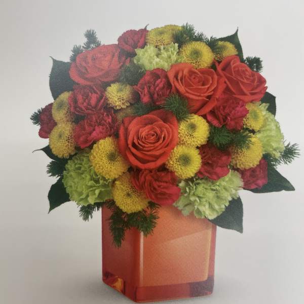 Bouquet of red roses, yellow blooms, and green flowers in an orange vase