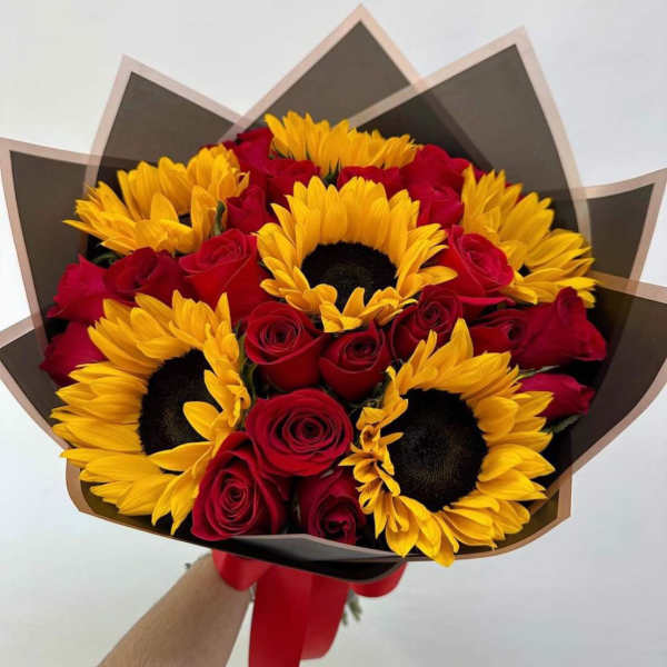 Bouquet of red roses and yellow sunflowers wrapped in dark paper