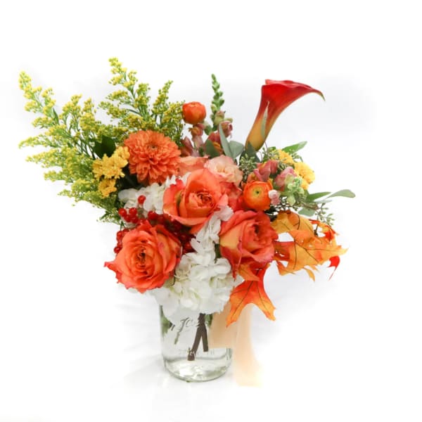 Orange and white mixed bouquet in a clear glass vase