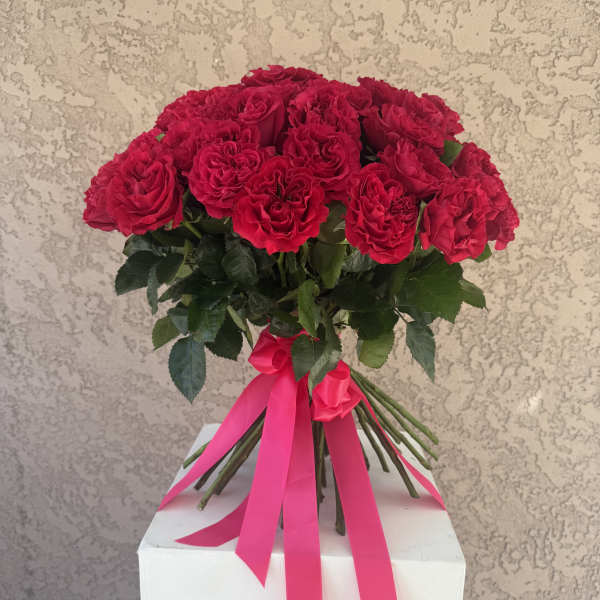 Bouquet of red roses tied with a pink ribbon