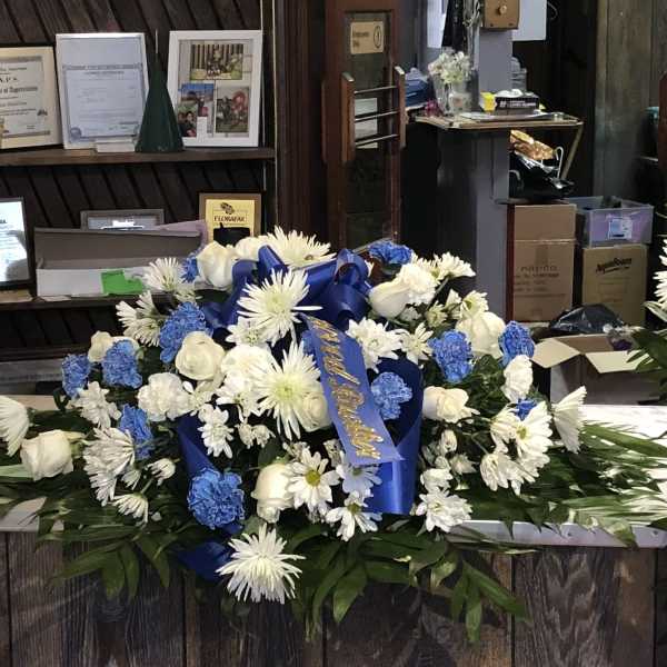 Large blue and white floral spray with ribbon on a counter