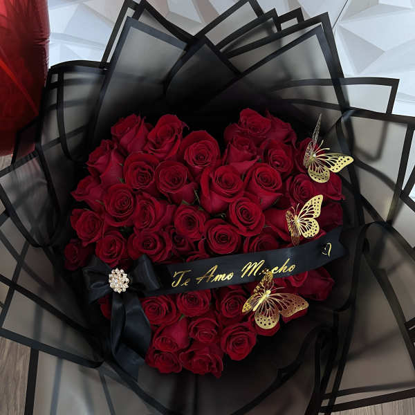 Bouquet of red roses wrapped in black paper with butterfly accents
