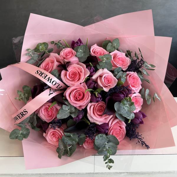 Pink rose bouquet with purple accents and eucalyptus in pink wrap
