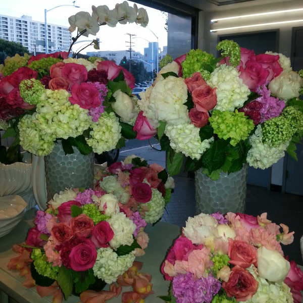 Large floral arrangements with pink roses and white orchids in tall vases