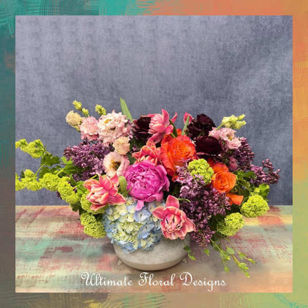 Colorful mixed flower arrangement in a low ceramic bowl