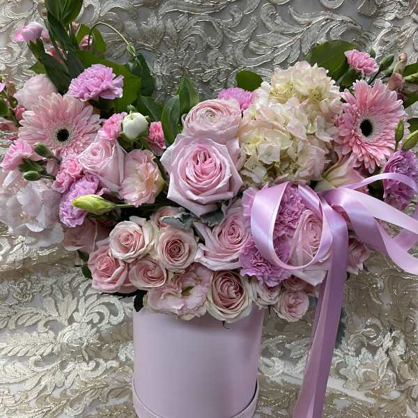 Pink roses and gerbera daisies in a lavender hatbox with ribbon