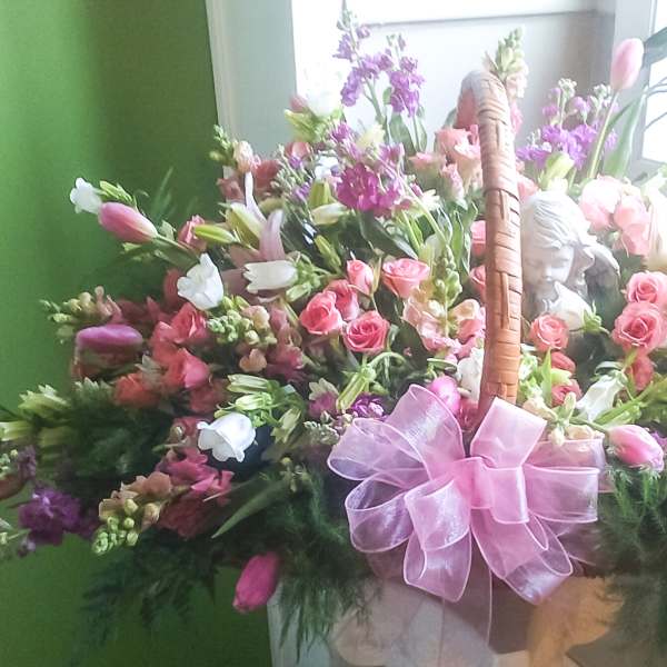 Basket of pink and white flowers with a pink bow