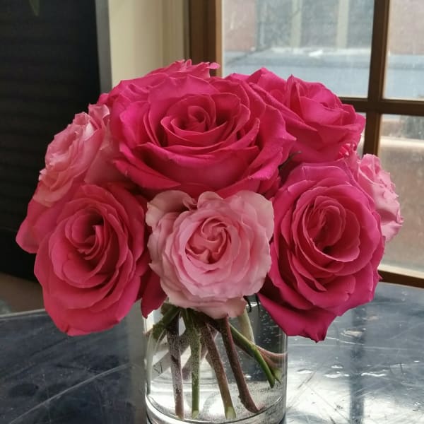 Pink roses arranged in a clear glass vase