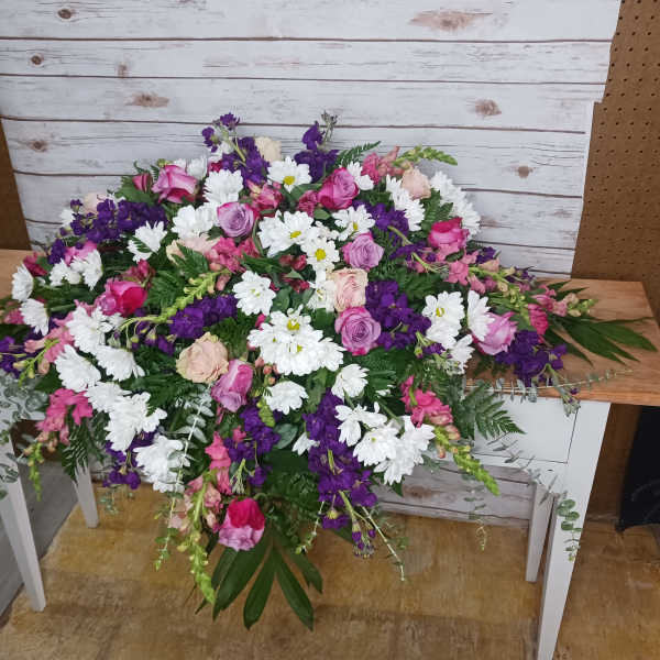 Large mixed bouquet of pink, purple, and white flowers on a table