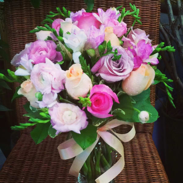 Pink and lavender bouquet in a glass vase with a ribbon