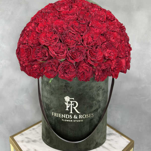 Large dome of red roses in a dark green hatbox