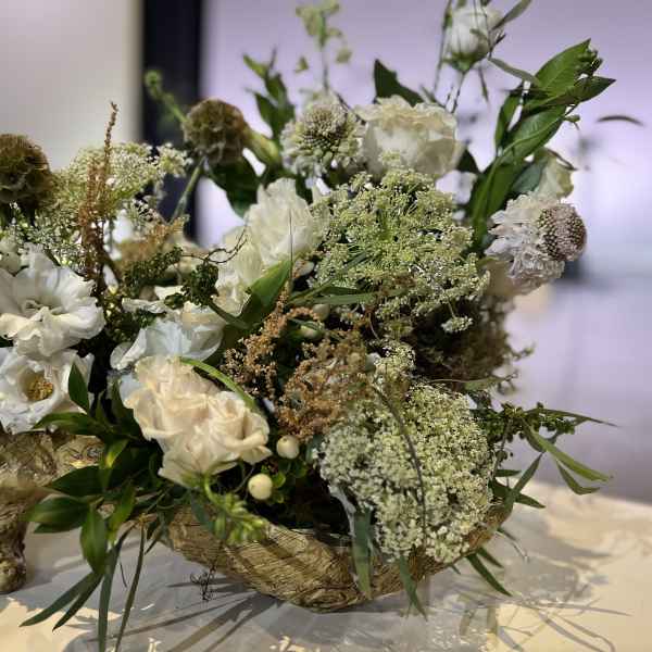 White floral arrangement in a rustic wooden container
