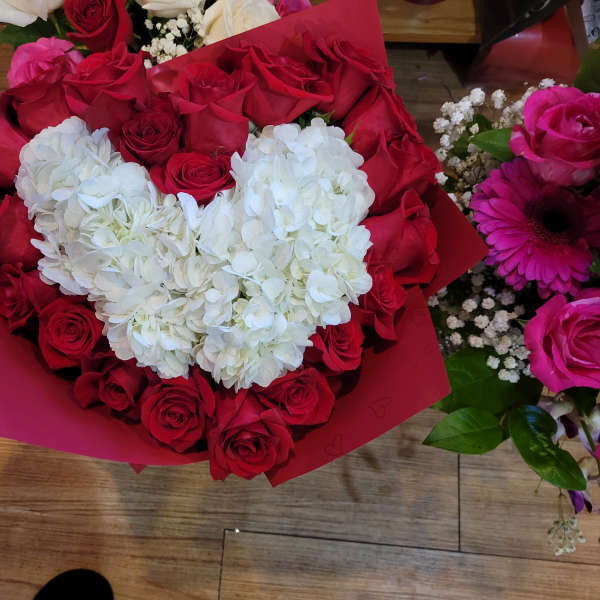 Heart-shaped bouquet of red roses with white hydrangeas