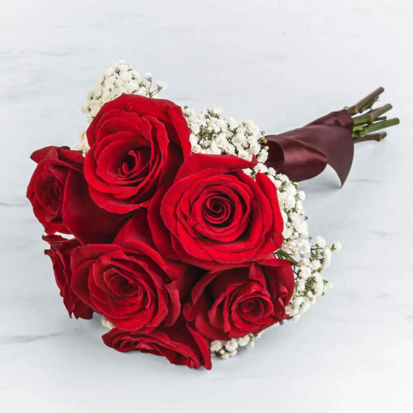 Bouquet of red roses with white baby's breath wrapped in burgundy paper