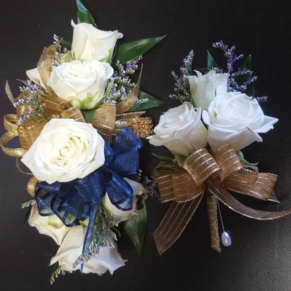White rose corsages with gold and blue ribbon accents