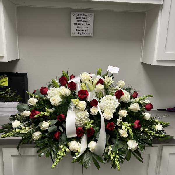 Large red and white funeral spray with roses and lilies