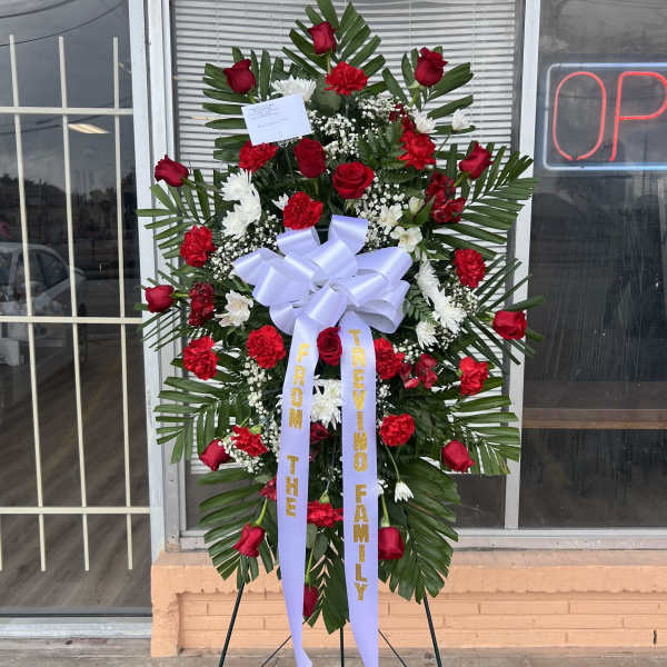 Standing floral wreath with red roses and white flowers on an easel