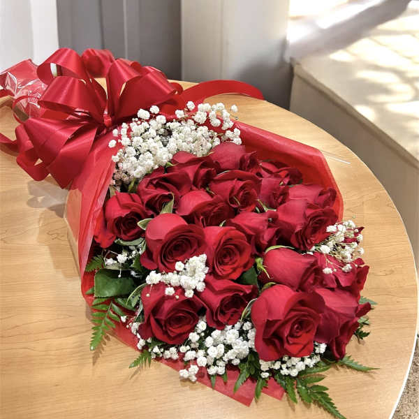 Bouquet of red roses with white baby's breath wrapped in red paper