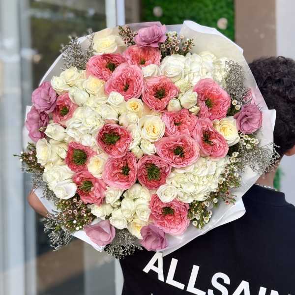 Large bouquet of pink and white flowers wrapped in white paper