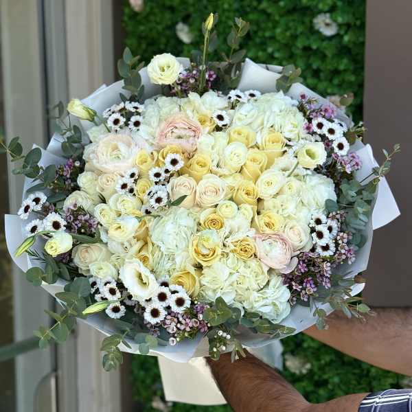 Large bouquet of pale roses, hydrangeas, and small daisies