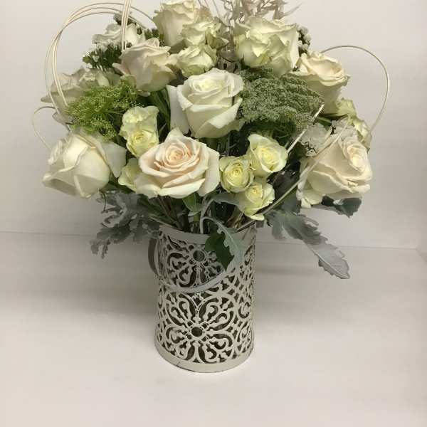 White rose arrangement in a decorative metal vase