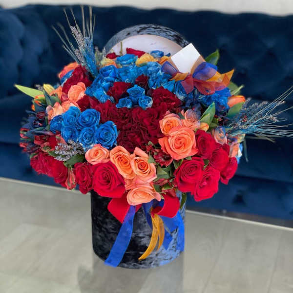Bouquet of red, blue, and peach roses in a black vase