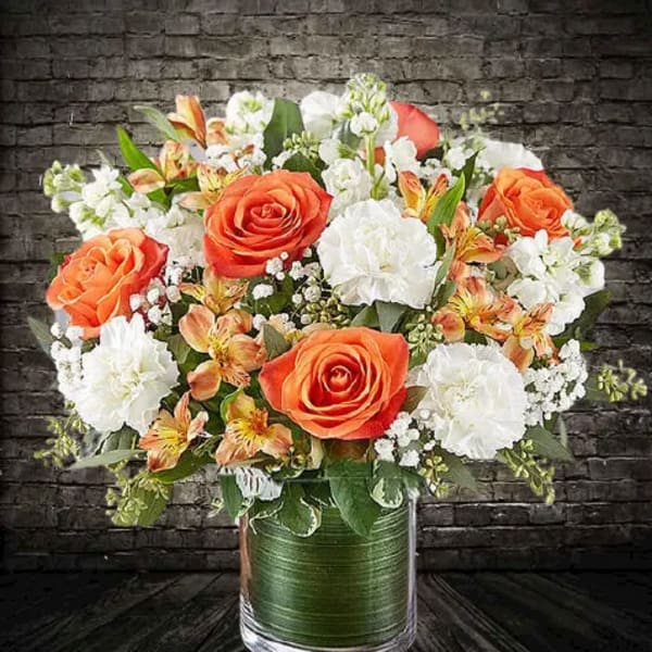 Orange and white mixed bouquet in a glass vase