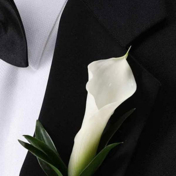 White calla lily boutonniere on a black suit jacket