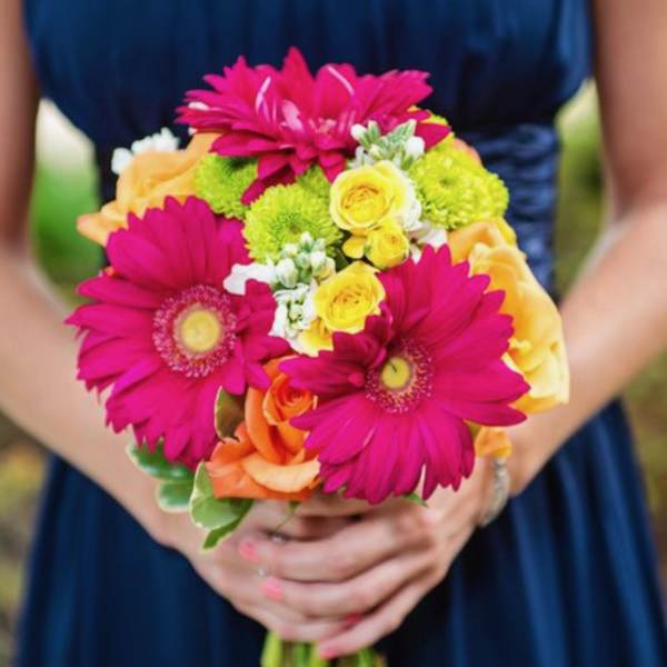 Bouquet of pink gerbera daisies, yellow roses, and orange roses