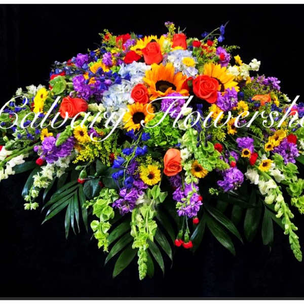 Large colorful floral spray with roses, sunflowers, and purple blooms on a black background
