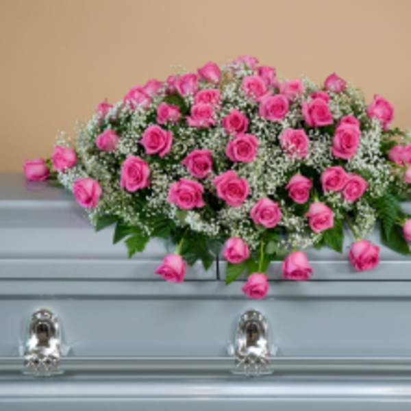 Pink rose casket spray with baby's breath on a light blue casket