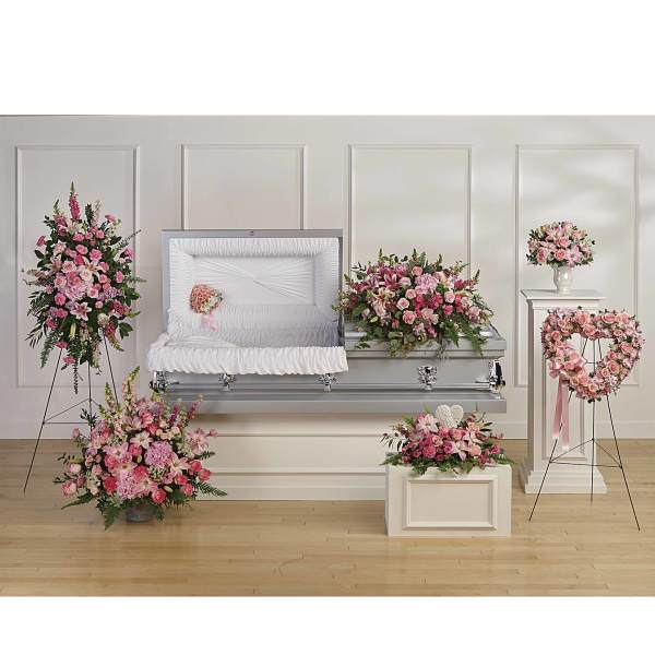 Pink floral funeral casket spray with matching wreaths and arrangements