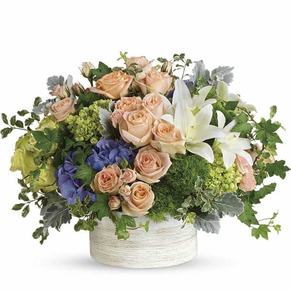 Peach roses and white lilies in a round white vase