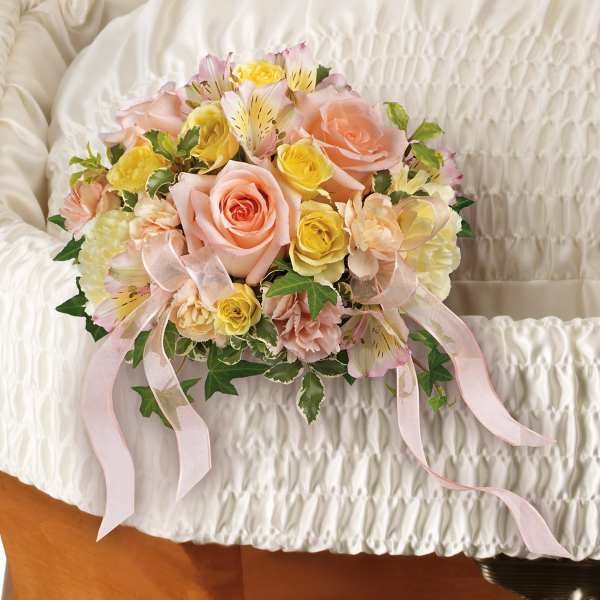 Pastel rose bouquet with ribbon on a white quilted surface