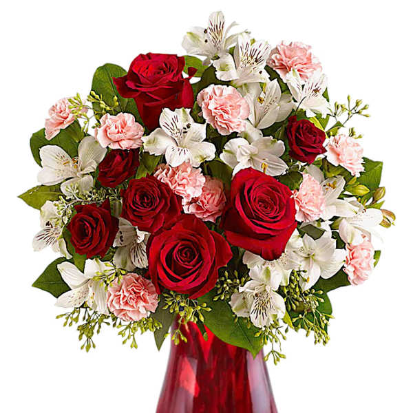 Red roses, white lilies, and pink carnations in a red glass vase